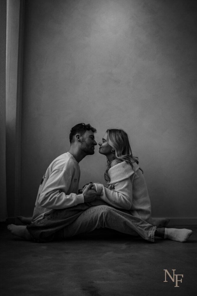 man en vrouw op de grond geven elkaar een kus